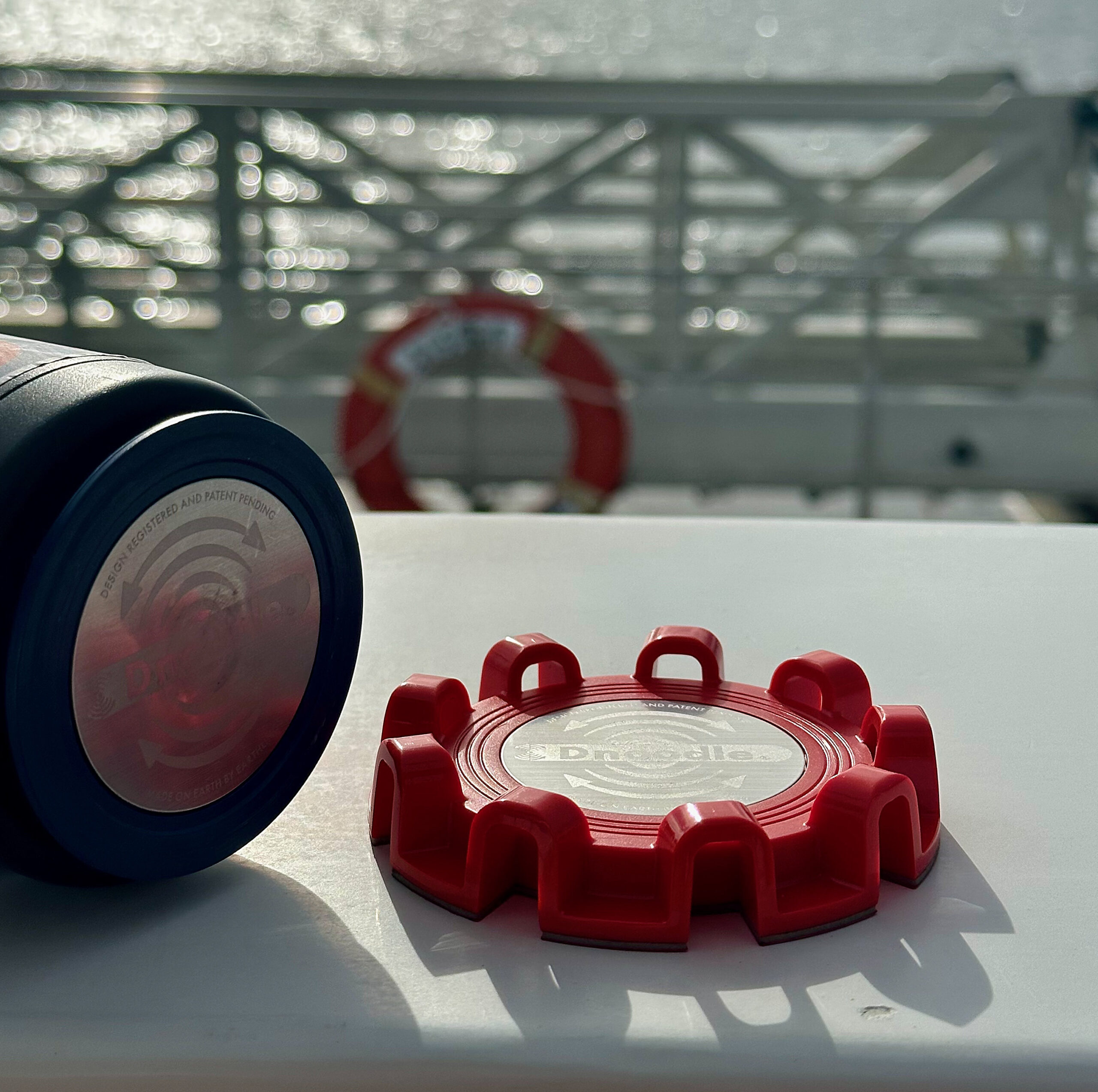 Close-up of the TwistLatch with adapter plate attached to a can cooler, set against a red life ring on a boat.
